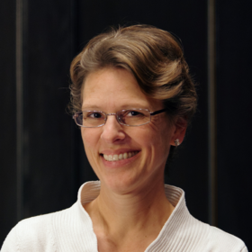 Ulrike Kolander: an assistant who wears short light hair, glasses and a white sweater.